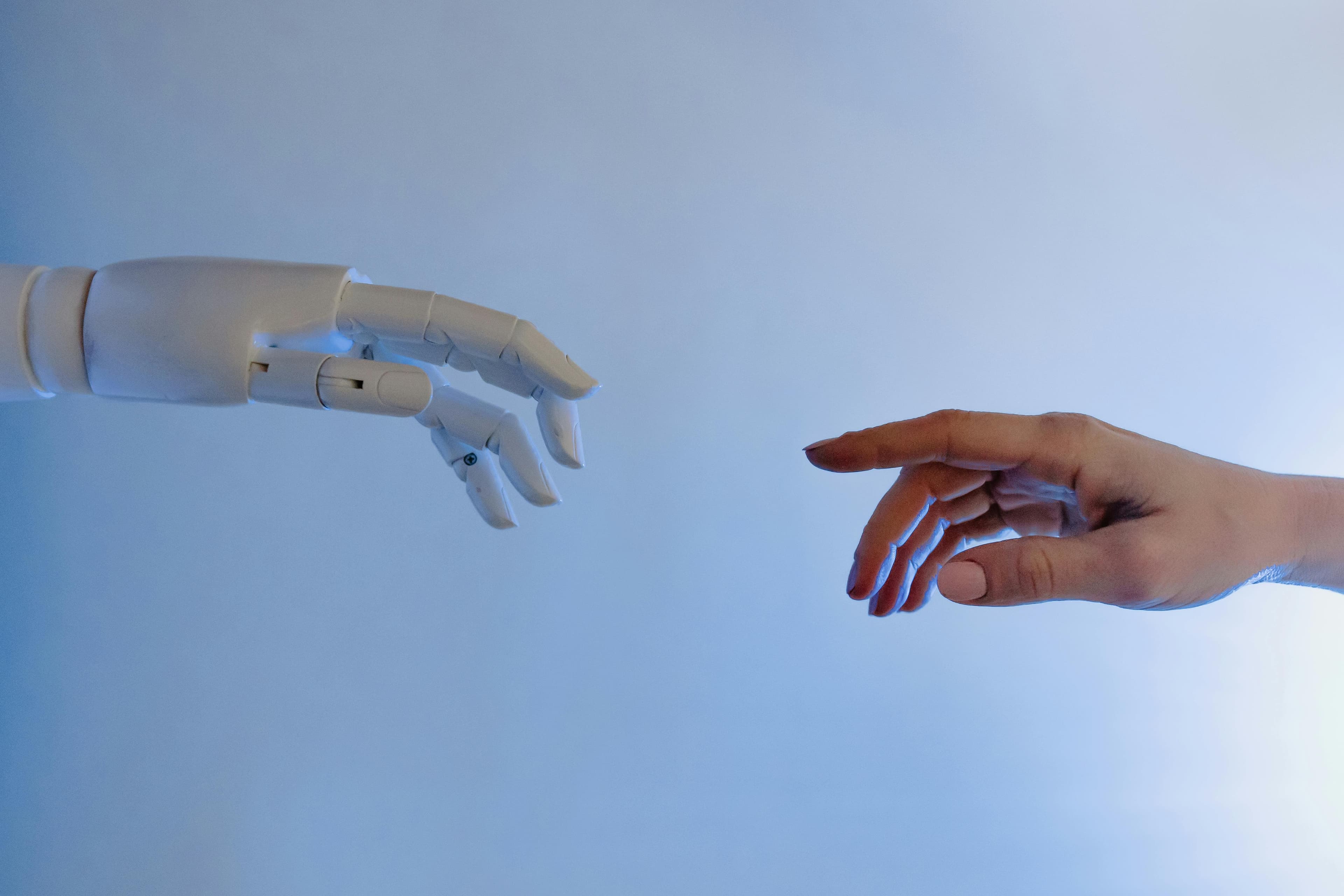 Robot hand reikend naar menselijke hand